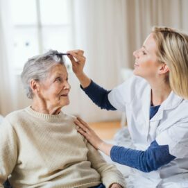 a-health-visitor-combing-hair-of-senior-woman-at-home-
